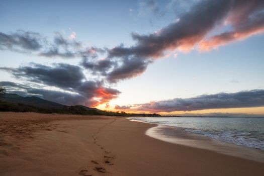 Capture of a breathtaking sunset over Makena Beach, Maui with vibrant skies and smooth ocean waves.
