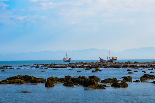 宁静的海景，船只停泊在岩石海岸附近，蓝天白云。 - 相关推荐