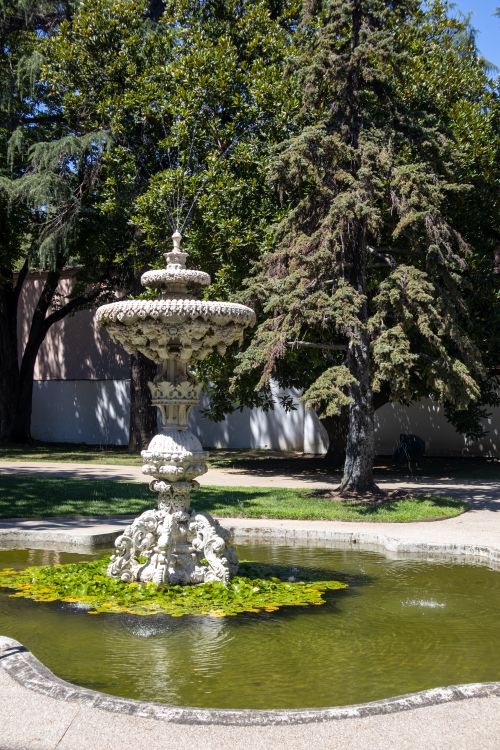 Free Beautiful stone fountain surrounded by lush greenery in a sunlit İstanbul park. Stock Photo