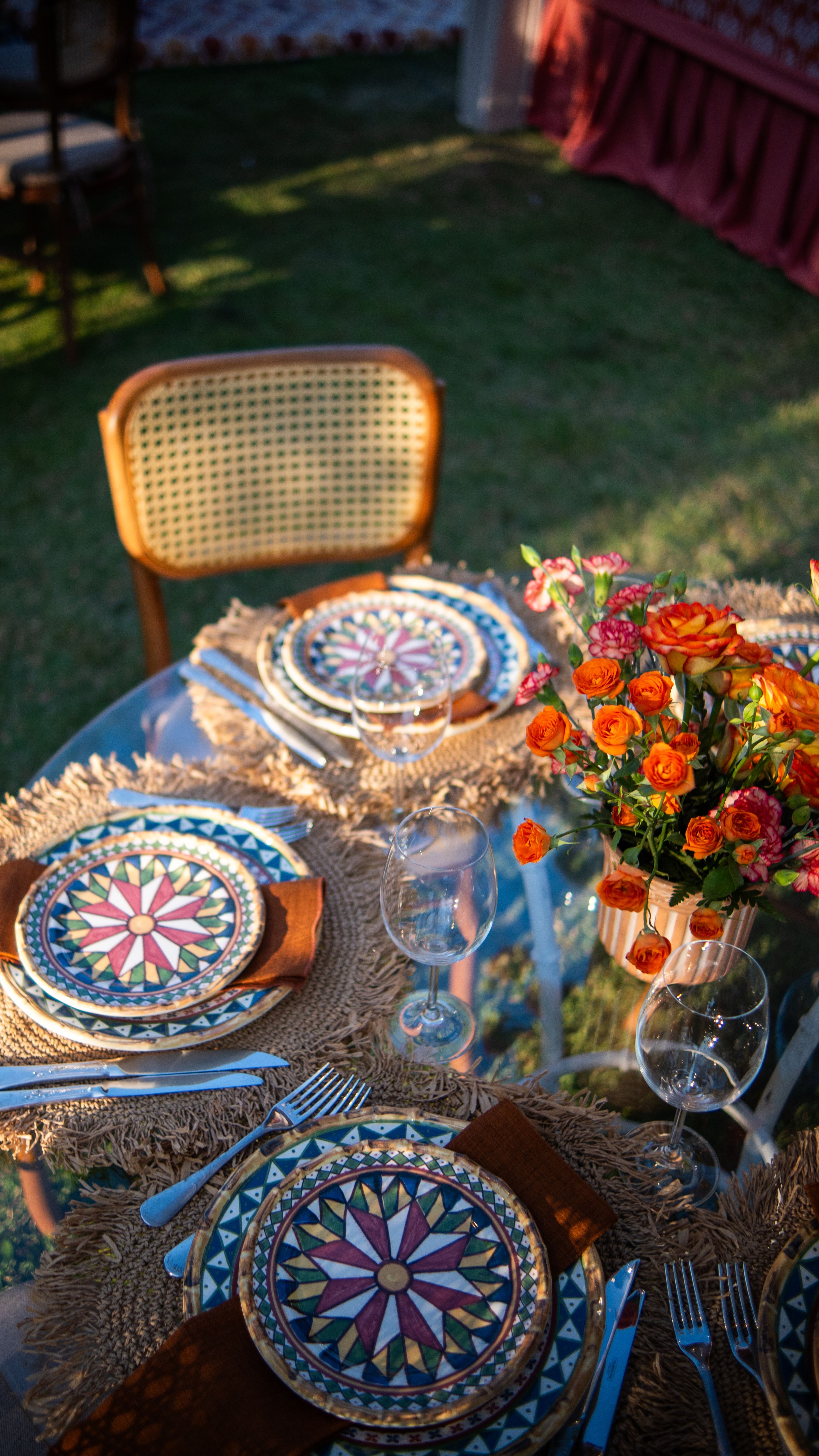 Um ambiente vibrante para refeições ao ar livre, com pratos artísticos e um arranjo de flores frescas em um dia ensolarado.