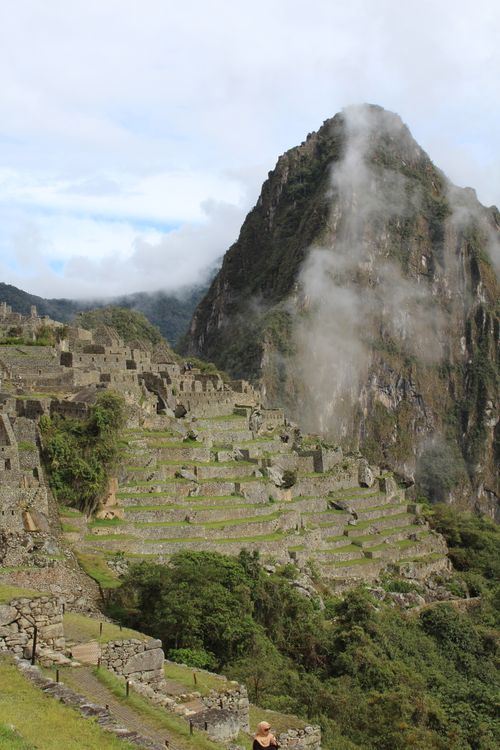 Free Scenic view of the ancient Inca ruins of Machu Picchu with misty mountain backdrop in Cusco, Peru. Stock Photo
