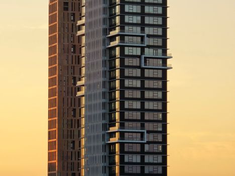 Close-up of two modern skyscrapers against a warm sunset sky, showcasing contemporary architecture.