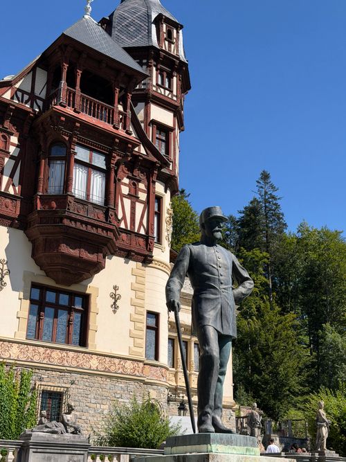 Free Historic statue view in Sinaia, Romania, with intricate architectural backdrop on a sunny day. Stock Photo