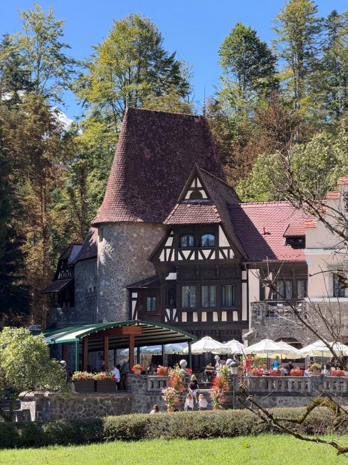 Free Scenic view of a charming Tudor-style building surrounded by lush greenery in Sinaia, Romania. Stock Photo