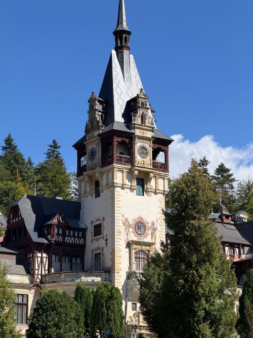 Free The iconic Peleș Castle tower gleaming under a bright blue sky in Sinaia, Romania. Stock Photo