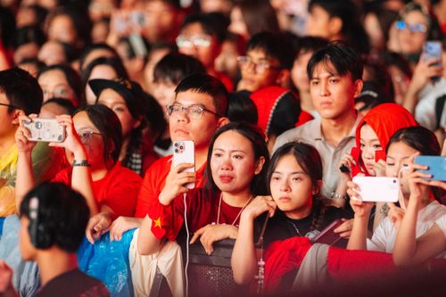 Free A diverse group of people at an outdoor concert event, engaged and capturing moments. Stock Photo