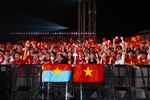 Free A lively crowd waves flags at a concert with vibrant colors and joyful expressions. Stock Photo