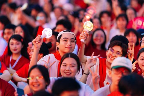Free A lively group of young people holding lights at a festival, celebrating in unity. Stock Photo