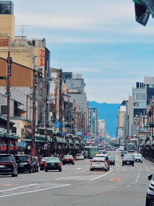 Free Typical day on a busy street in Kyoto, Japan, with city buildings and cars. Stock Photo