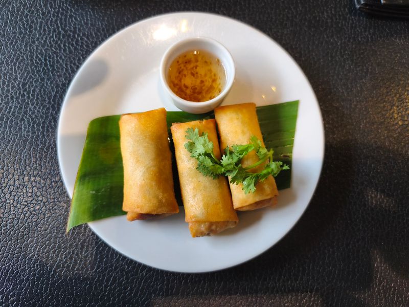 Thai fresh rolls served with dipping sauce on a banana leaf