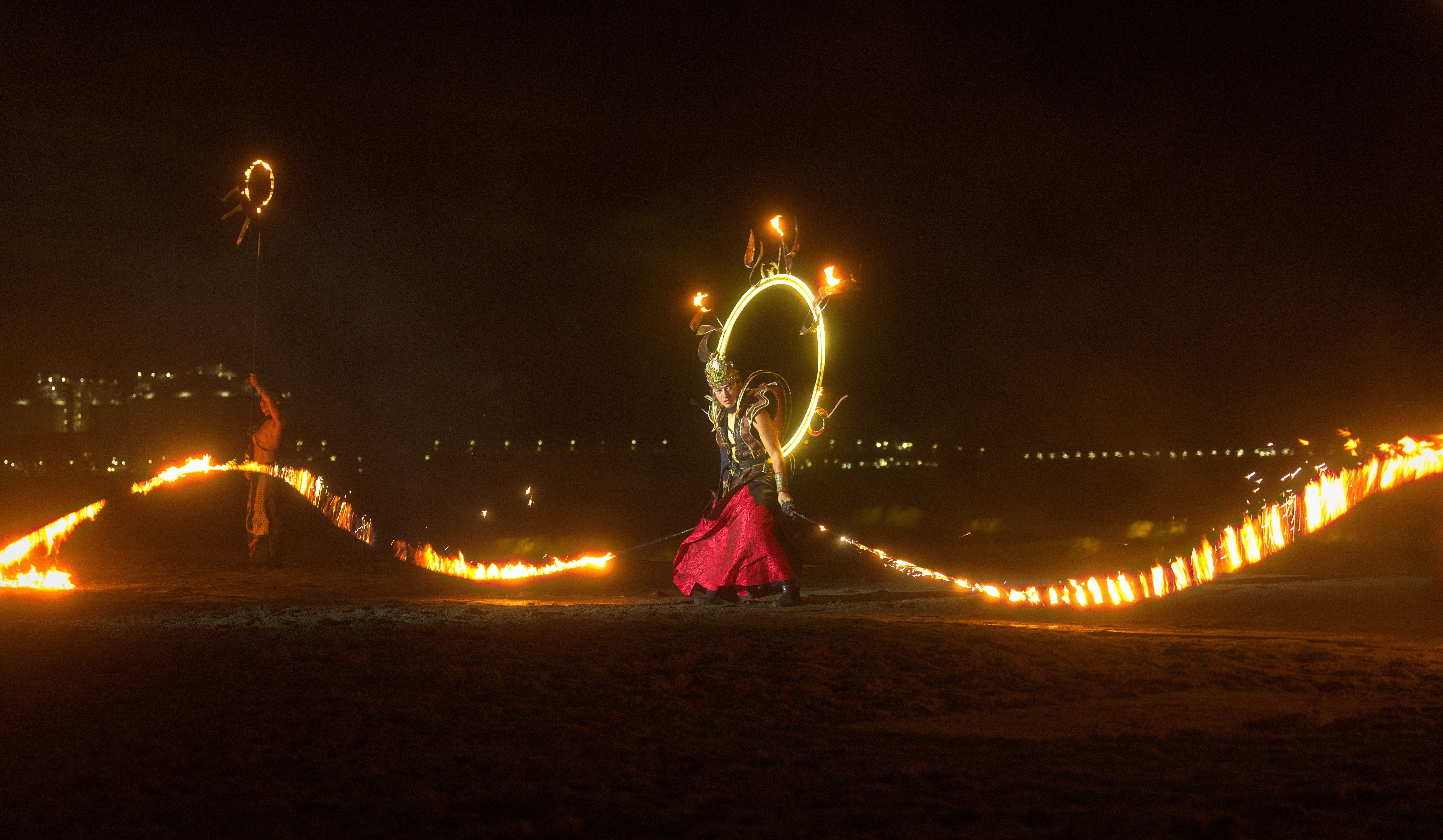 Dynamic fire dancer performing at night, creating a vibrant spectacle with flames.