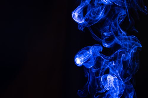 Free Dynamic display of luminous blue smoke swirling against a dark backdrop. Stock Photo