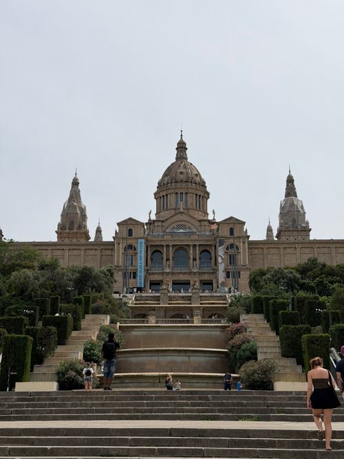 Free The majestic Palau Nacional in Barcelona with steps leading up, set against a cloudy sky. Stock Photo
