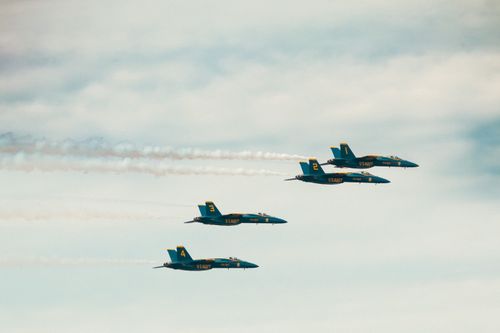 Free Four fighter jets performing in perfect formation against a clouded sky at an airshow. Stock Photo