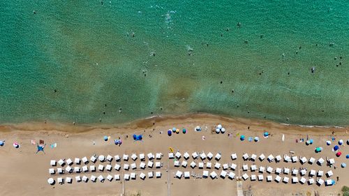 Free Stunning aerial shot of a lively beach in Greece with sunbathers and turquoise waters. Stock Photo