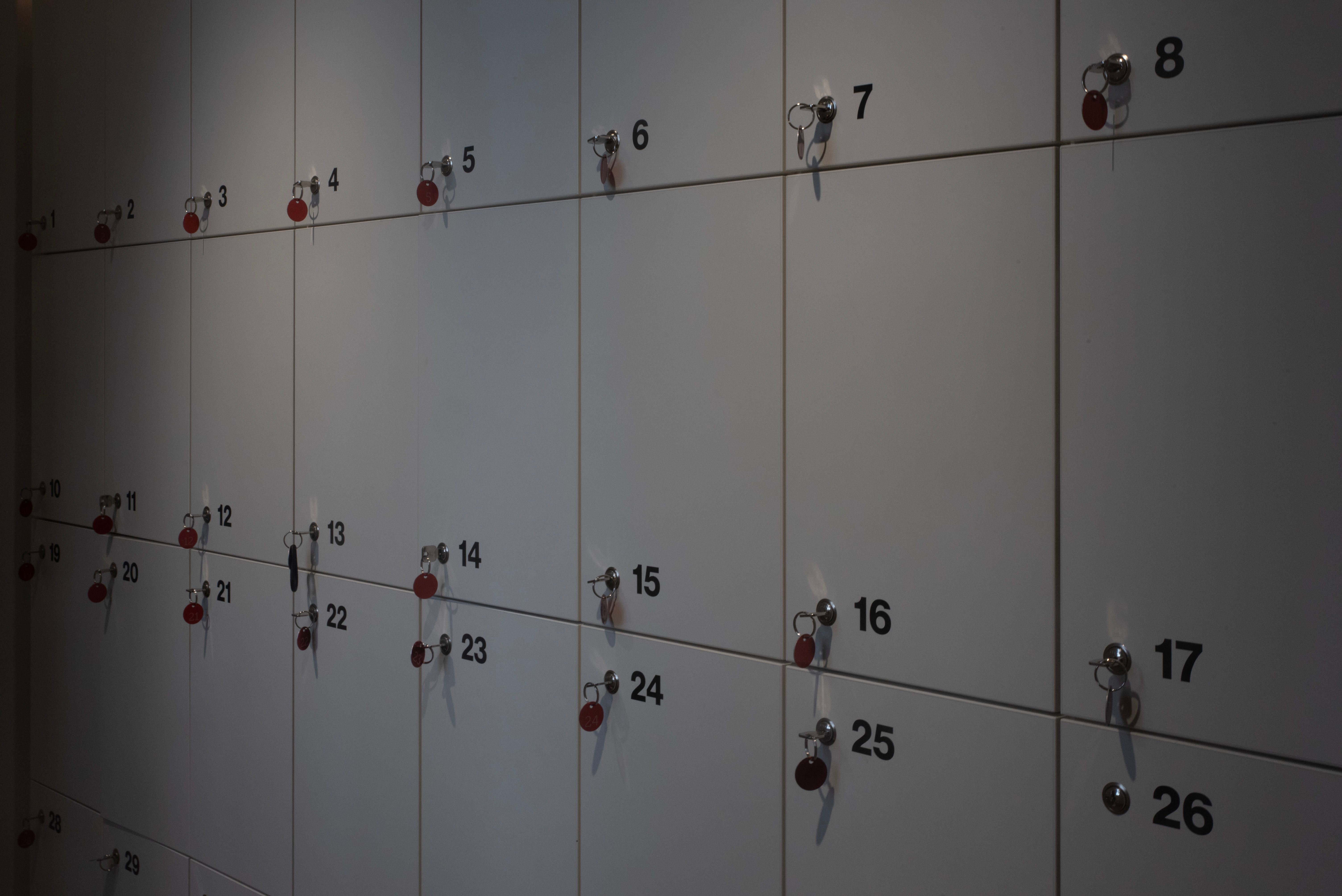 A row of wall-mounted lockers with keys in an indoor setting, ideal for storage solutions.
