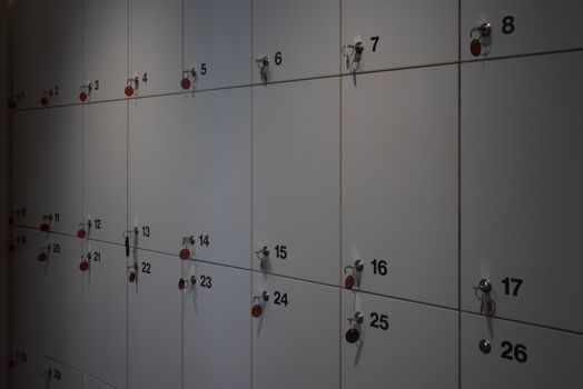 A row of wall-mounted lockers with keys in an indoor setting, ideal for storage solutions.