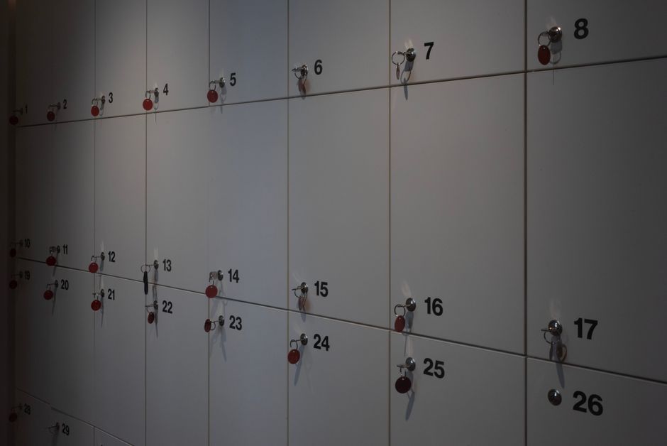 A row of wall-mounted lockers with keys in an indoor setting, ideal for storage solutions.