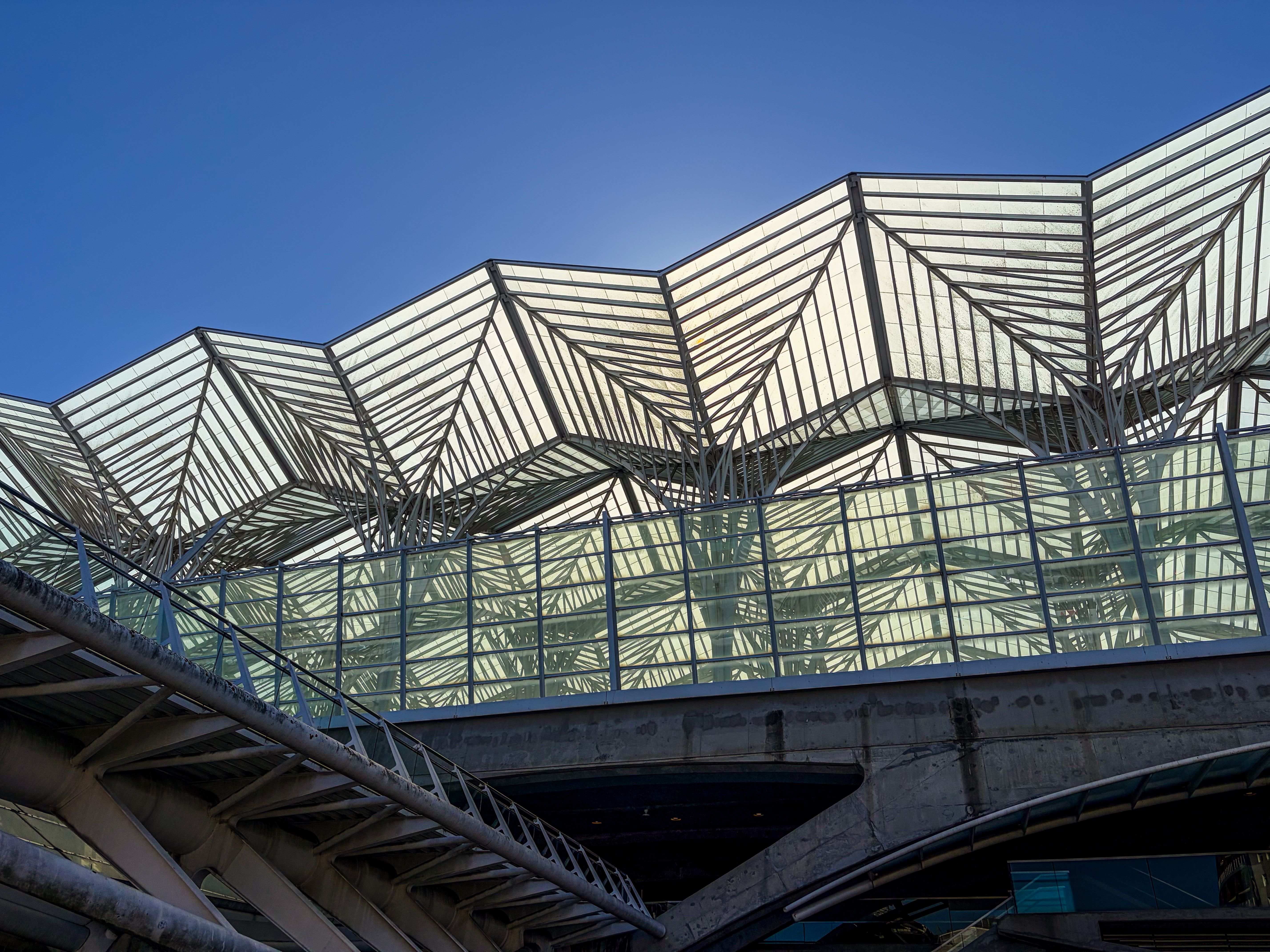 Striking geometric design of Lisbon's Oriente Station under a clear blue sky.