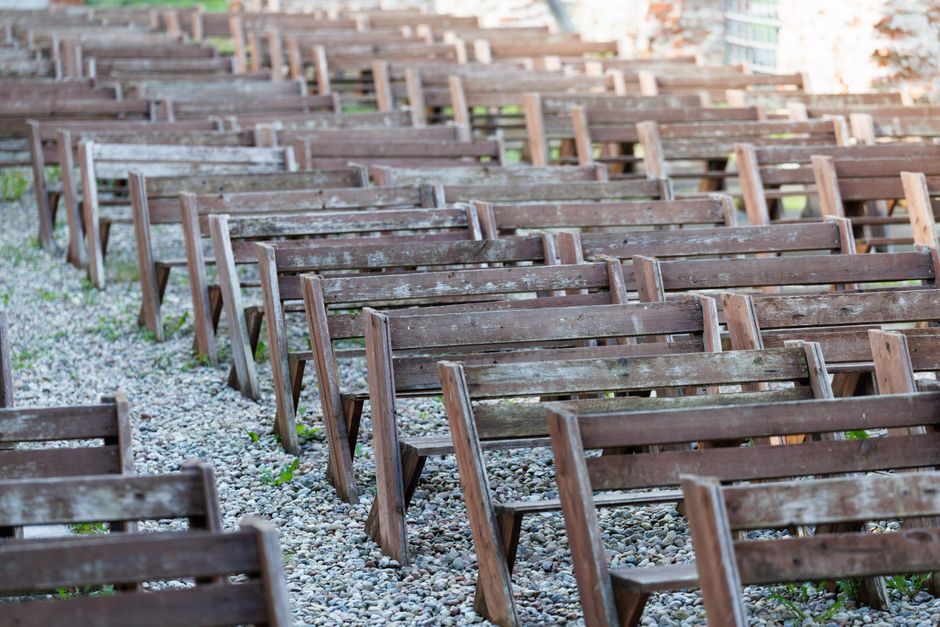 A series of rustic wooden benches arranged on gravel in Kaliningrad, Russia.