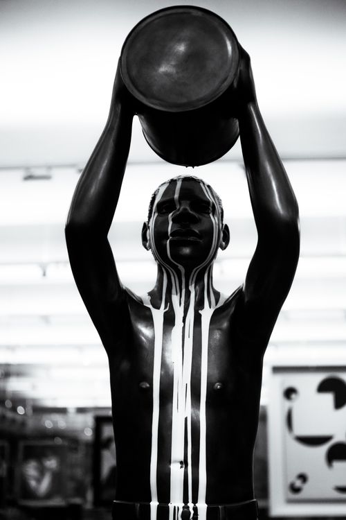 Free Striking black and white artwork of a man holding a bowl in an artistic setting. Ideal for art and culture themes. Stock Photo