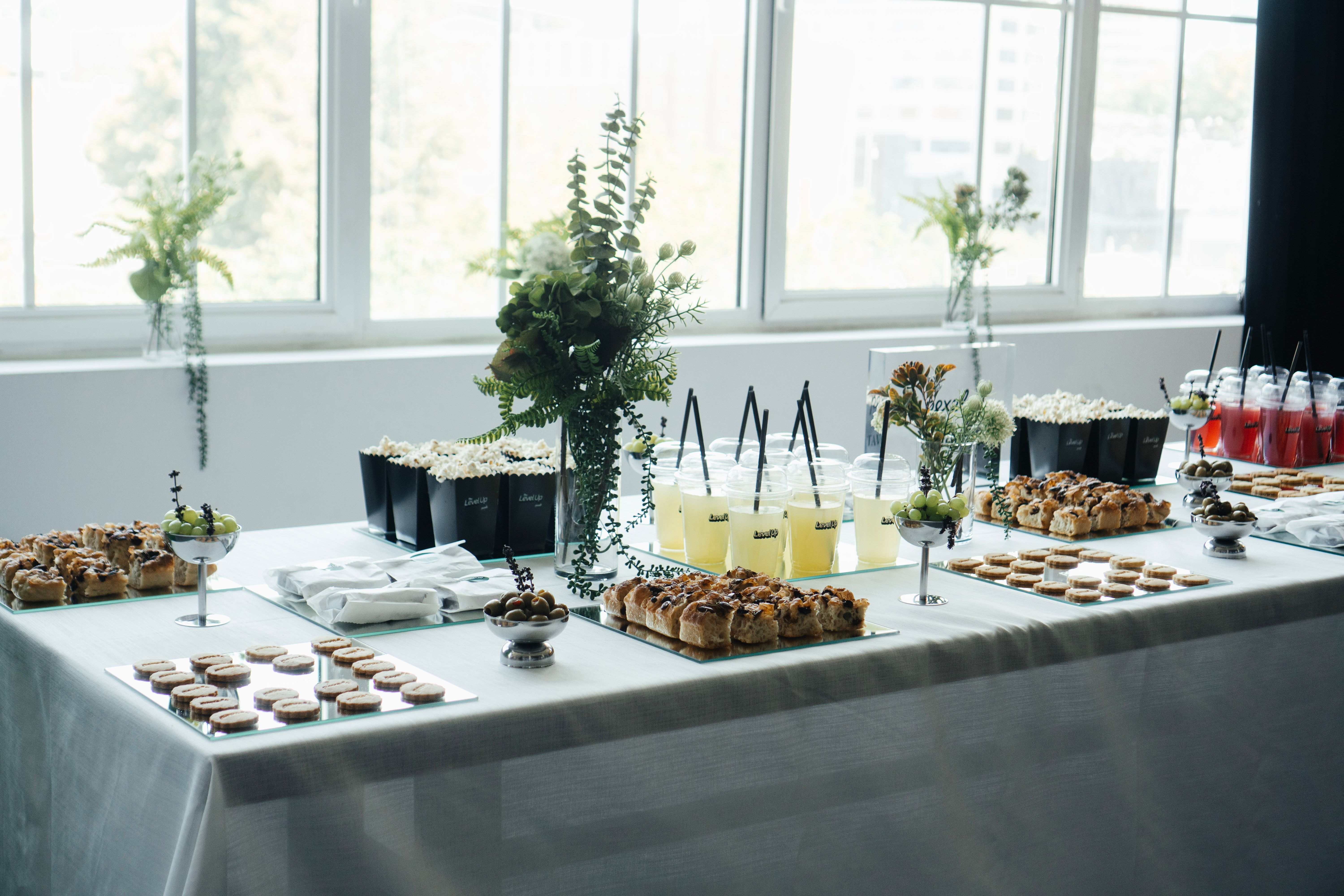 A well-arranged buffet with snacks and drinks in an elegantly decorated indoor setting.
