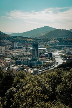 A breathtaking aerial shot of Bilbao, capturing the cityscape and mountains under a clear sky.