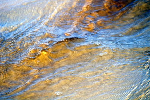 Free Close-up of water gently flowing over a sandy riverbank in Paraná, Brazil. Stock Photo