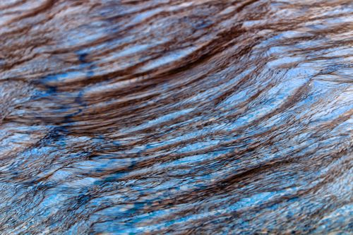 Free Artistic capture of textured water surface, displaying flowing lines and natural colors. Stock Photo