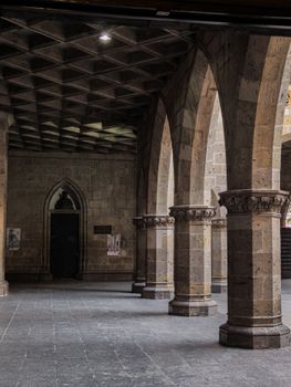 Stone arches in a historic building in Guadalajara, showcasing detailed architecture.