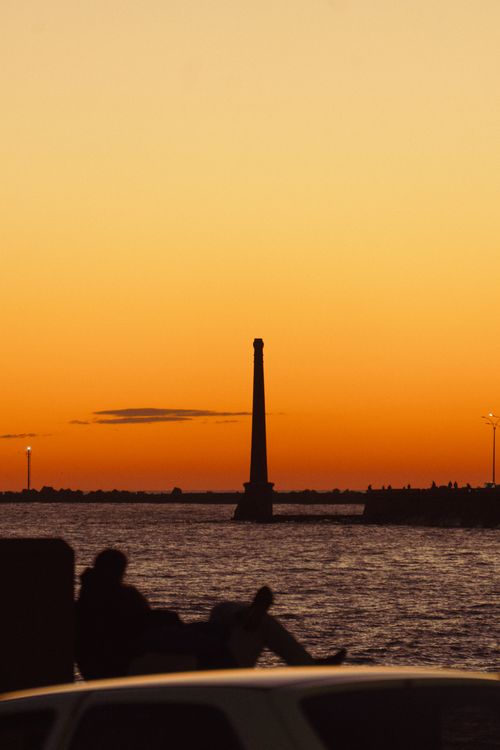 Free A stunning sunset view over Montevideo harbor with silhouettes and vibrant colors. Stock Photo
