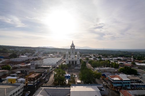 Free Aerial view of the scenic cityscape of Zacatecoluca, featuring its main church under the morning sun. Stock Photo