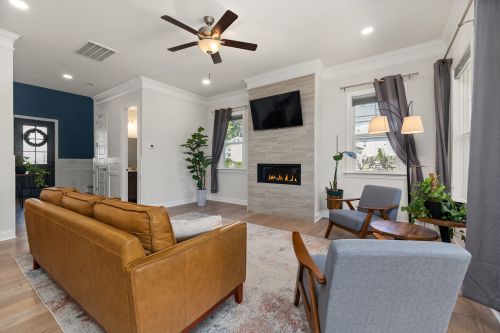 Free Bright modern living room featuring cozy fireplace, stylish furniture, and indoor plants. Stock Photo