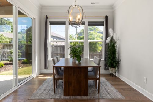 Free Sunlit dining room with modern furniture, large windows, and stylish decor. Stock Photo