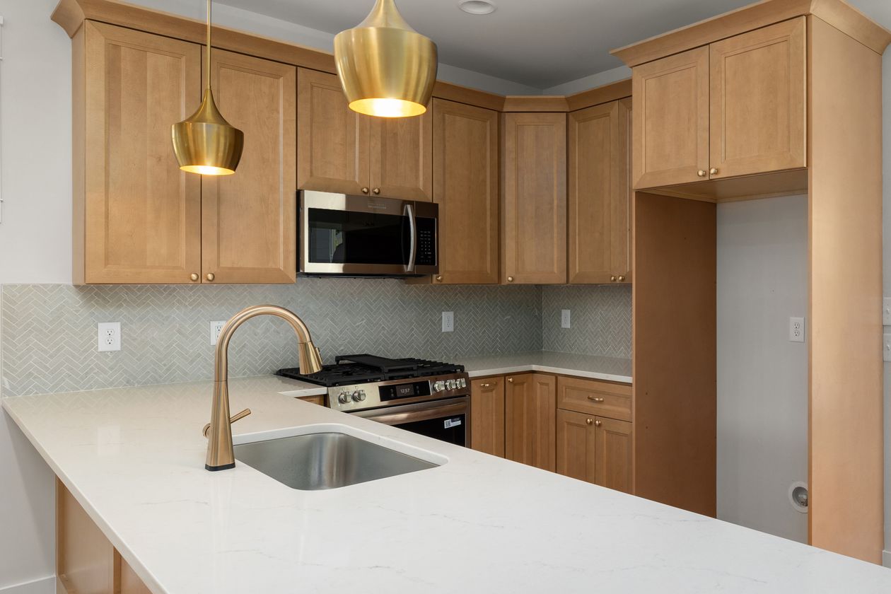 Wood cabinets with brass fixtures in a warm kitchen
