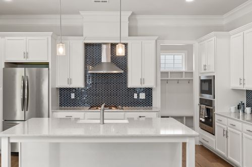 Free Elegant modern kitchen with white cabinets, island, and hexagonal tile backsplash. Stock Photo