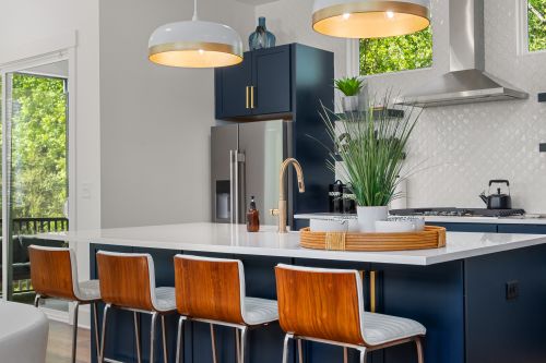 Free Bright modern kitchen interior with sleek design, island seating, and pendant lighting. Stock Photo