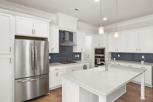 Free Sleek contemporary kitchen featuring white cabinets, quartz countertops, and stainless steel appliances. Stock Photo