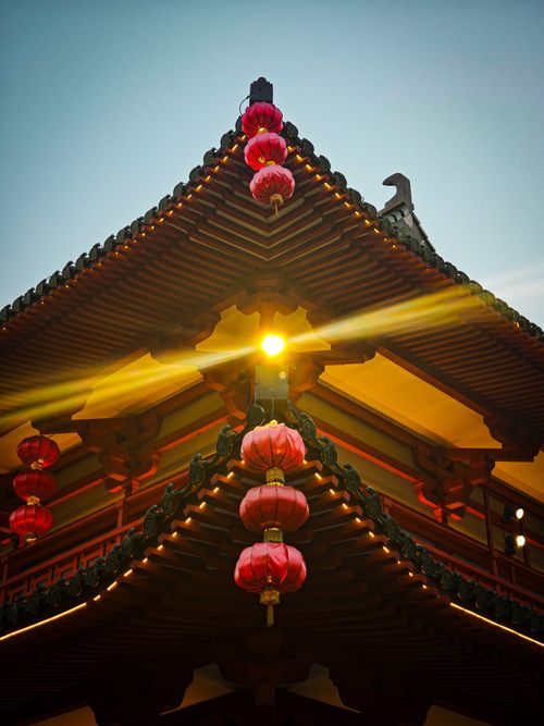 Free Close-up of a traditional Chinese temple roof adorned with red lanterns during the day. Stock Photo