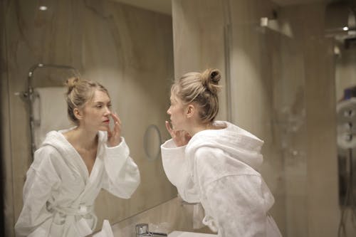 Woman in White Robe In Front of the Mirror