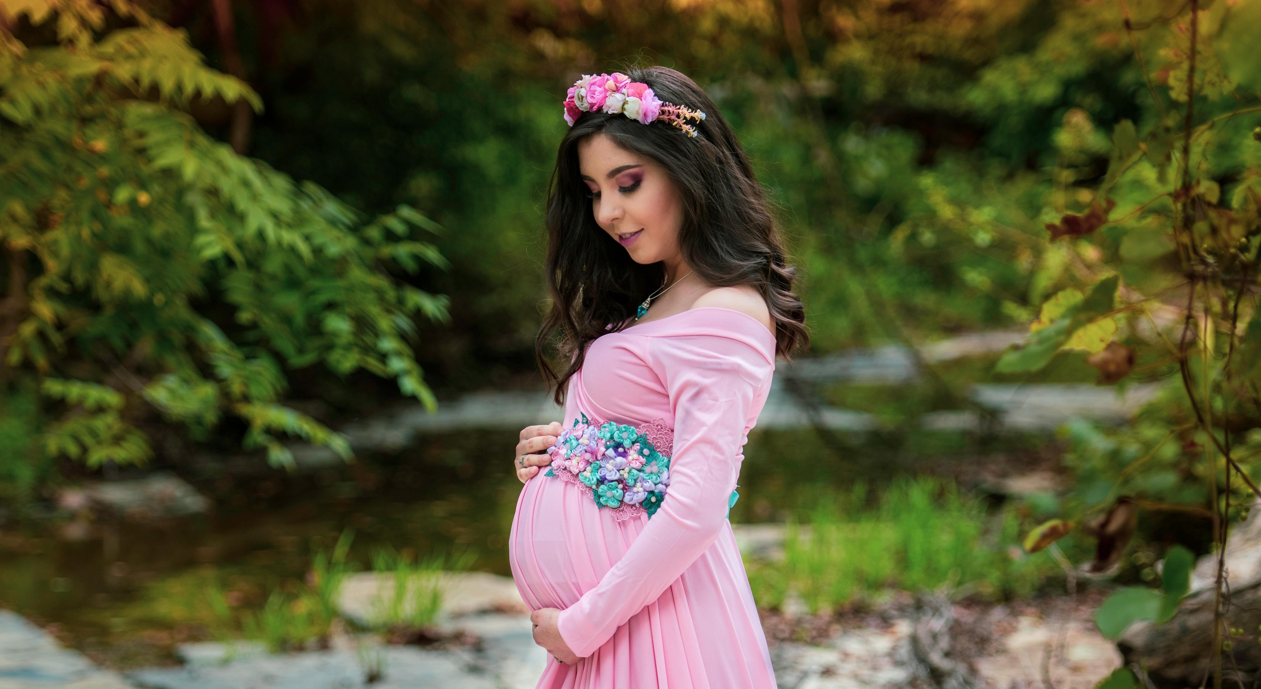 在大自然中，美丽的孕妇肖像捕捉了期待的喜悦