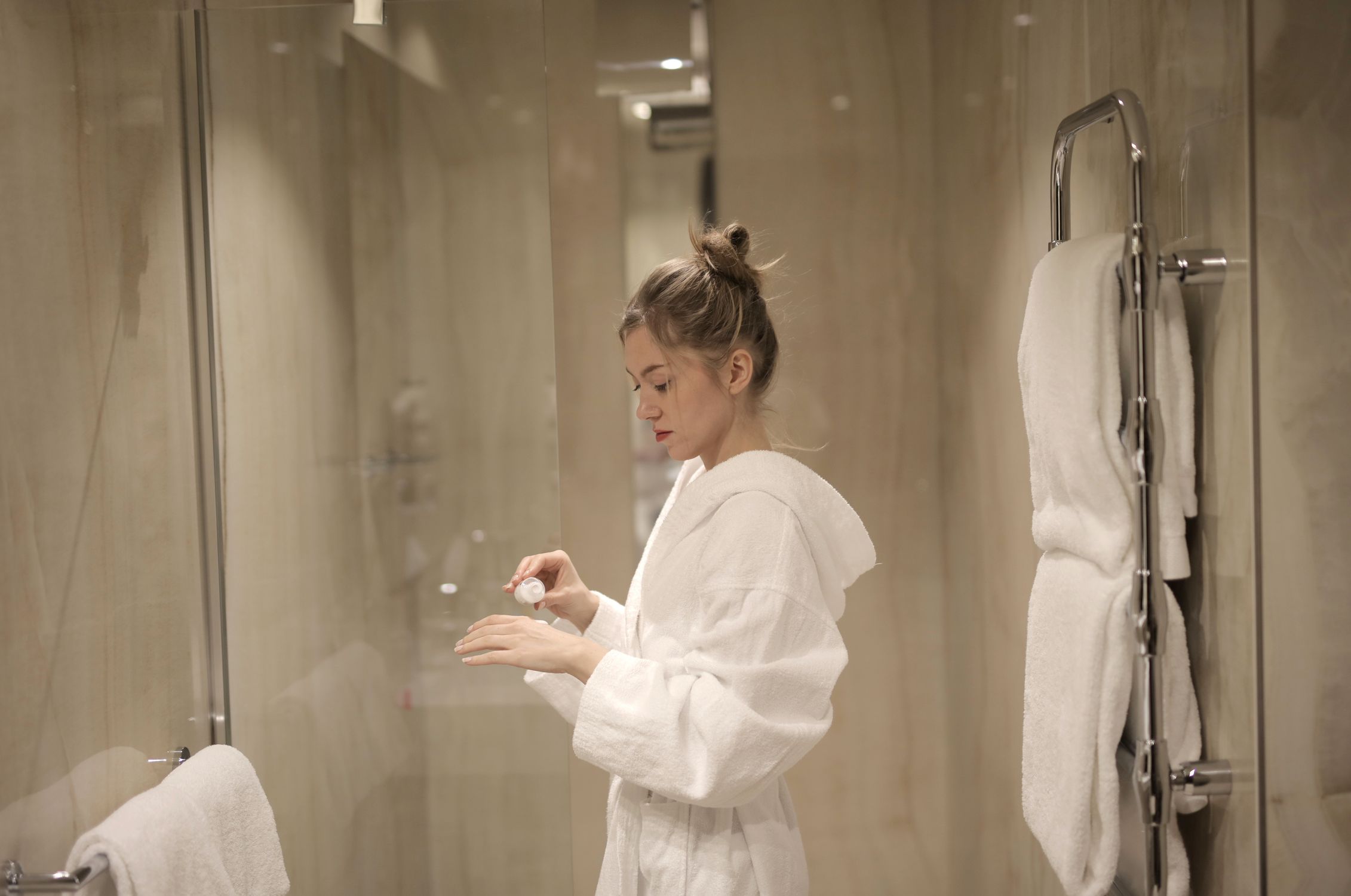 Putting On Robe Woman in White Robe Putting Lotion · Free Stock Photo