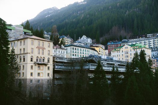 Picturesque view of historic buildings nestled in the hills of Bad Gastein, Austria, surrounded by lush forests.