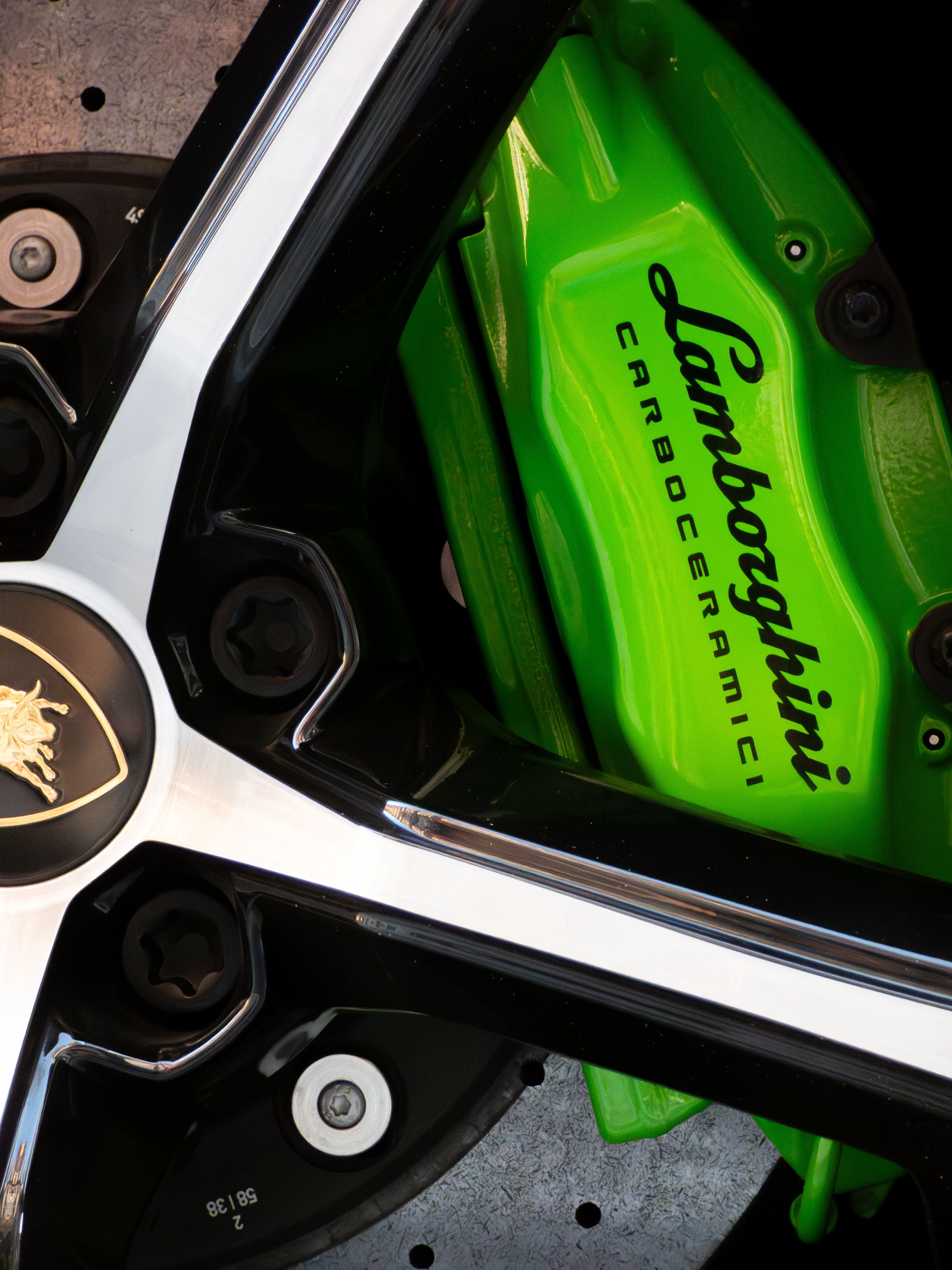 Fotomural Imagen detallada de una pinza de freno de cerámica de carbono verde de Lamborghini con rueda.