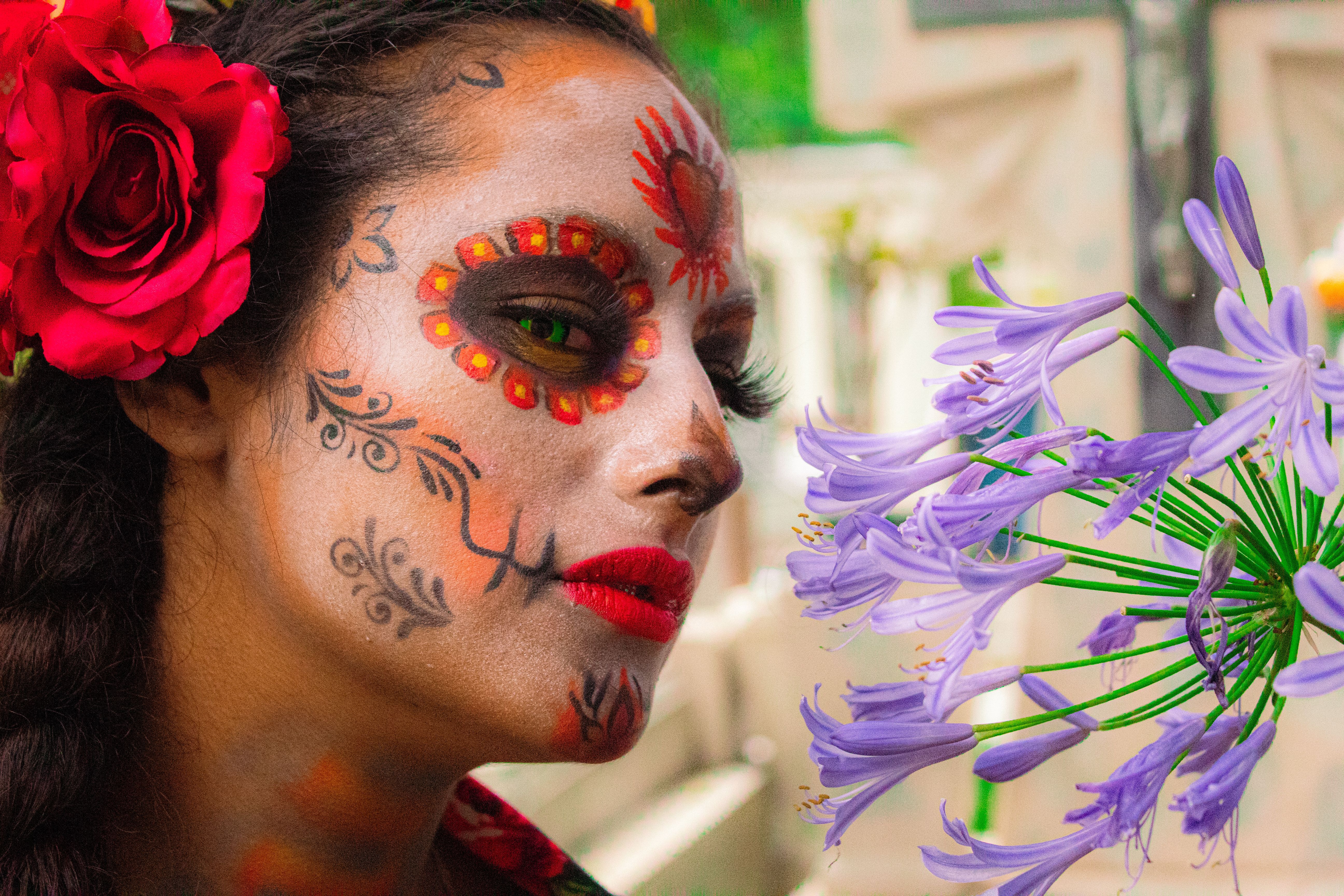 Colorful Day of the Dead face paint featuring floral designs and vibrant flowers.
