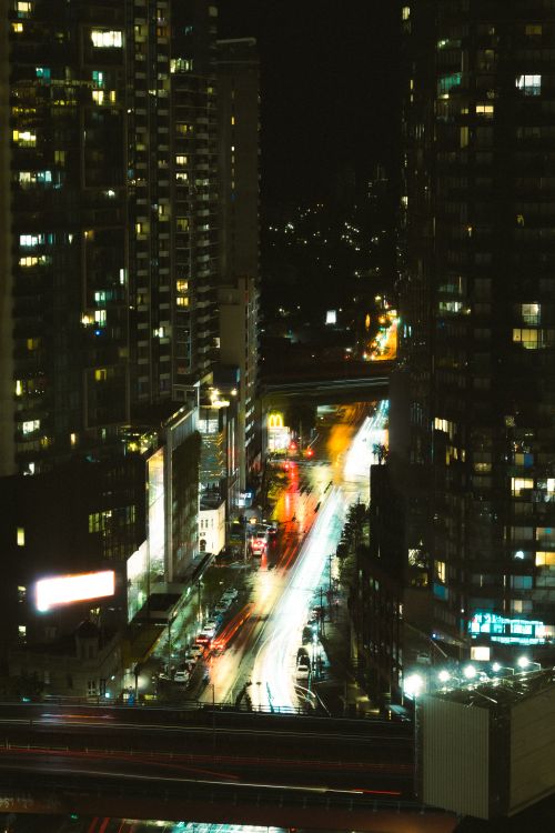 Free Dynamic view of Melbourne's cityscape at night featuring vibrant light trails and towering buildings. Stock Photo