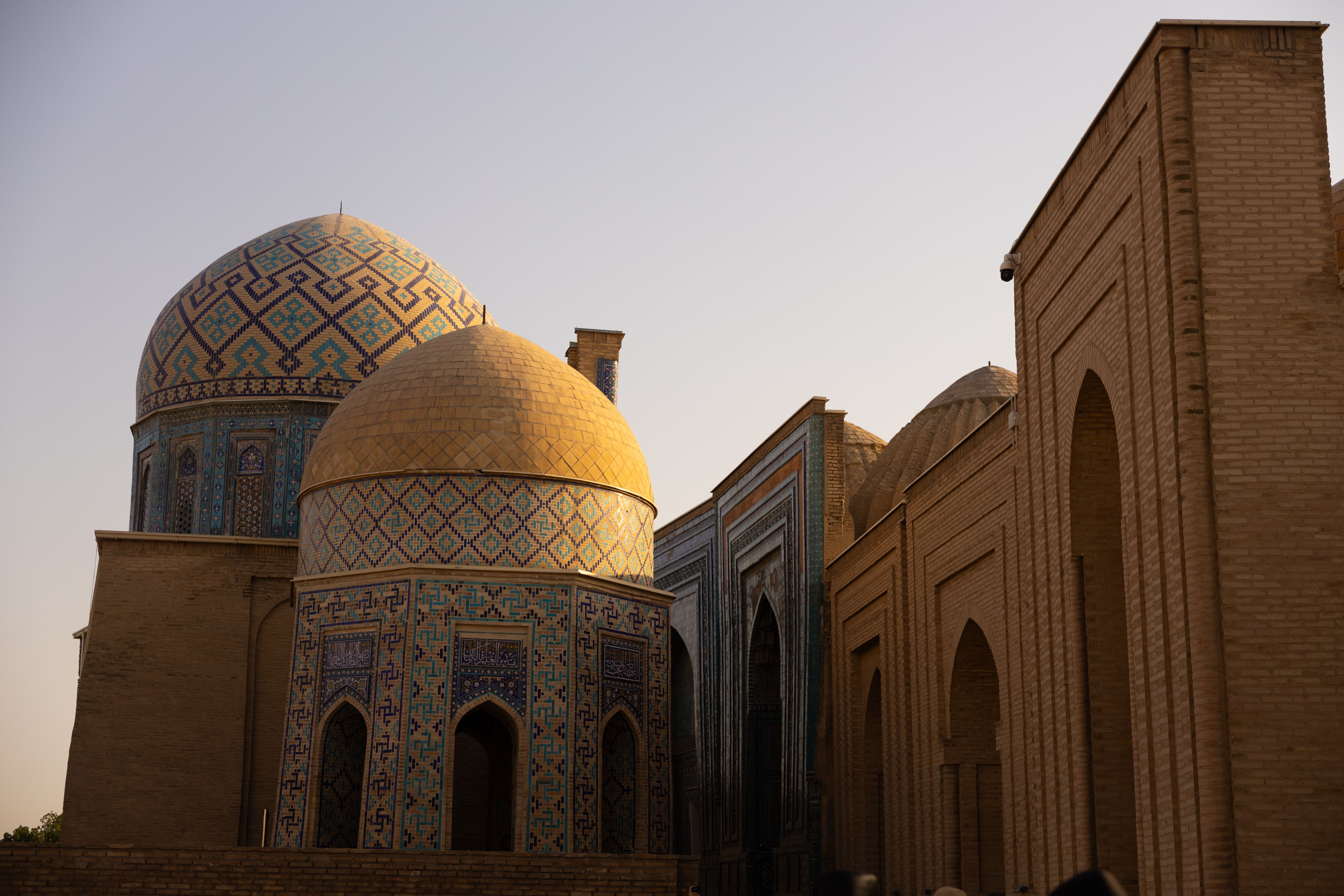 Golden hour illuminating the domed architecture of Samarkand, showcasing elegant patterns and history.