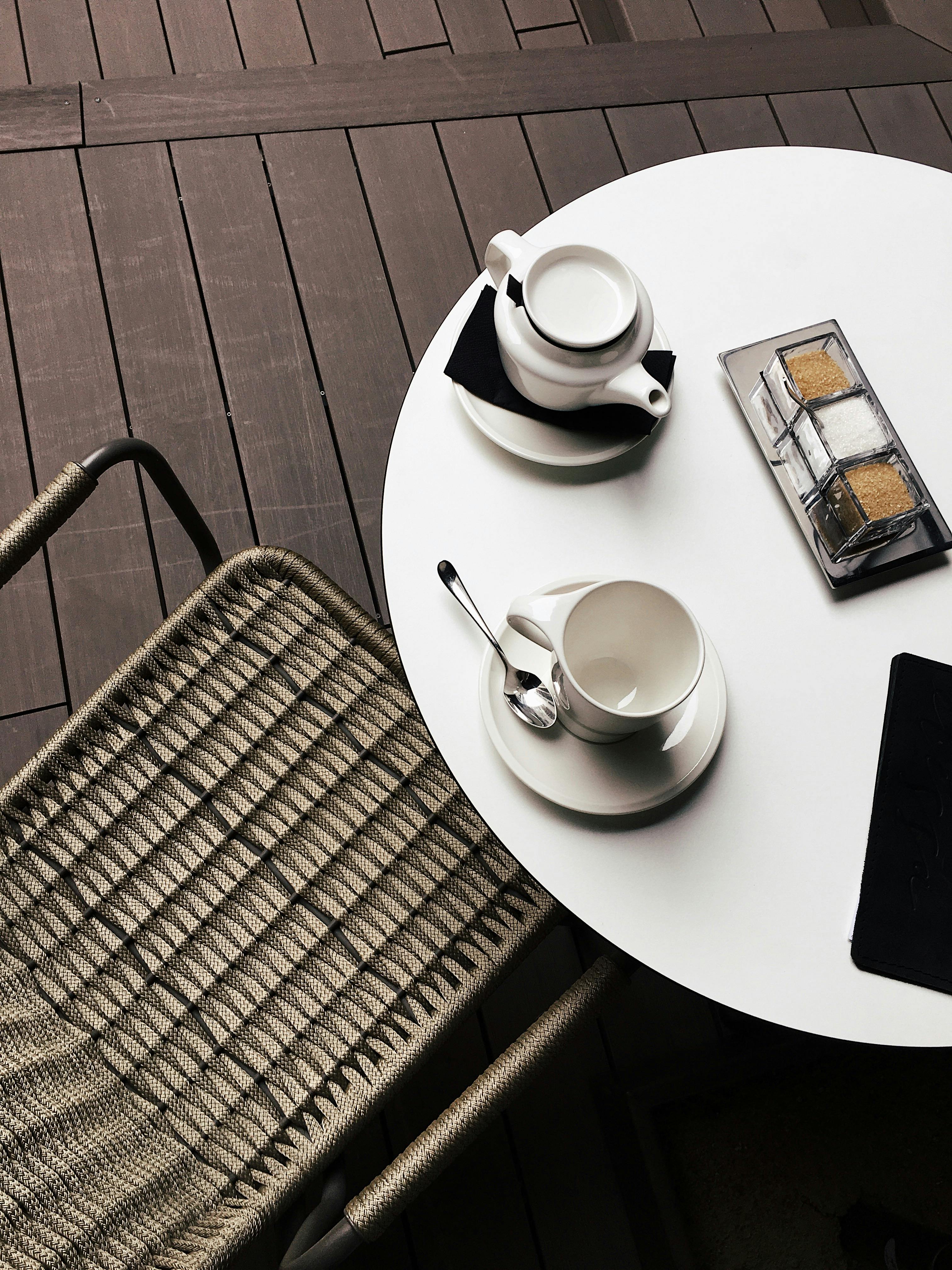 咖啡馆氛围舒适，圆桌上放着一个白色咖啡杯，正是放松的好时刻