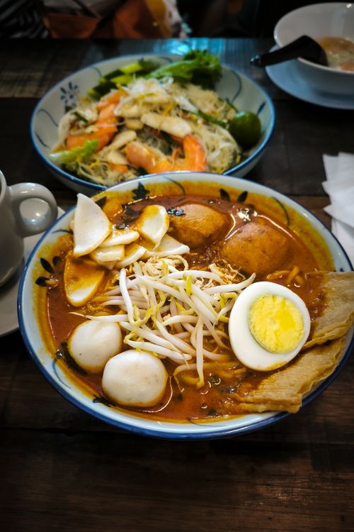 Free Tasty laksa and seafood noodle dishes served in a cozy Johor Bahru restaurant setting. Stock Photo