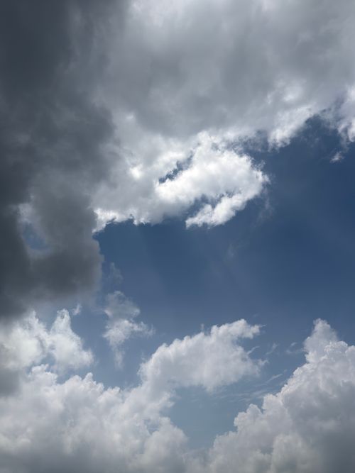 Free A vibrant sky view capturing dramatic clouds and sunlight beams on a clear day. Stock Photo